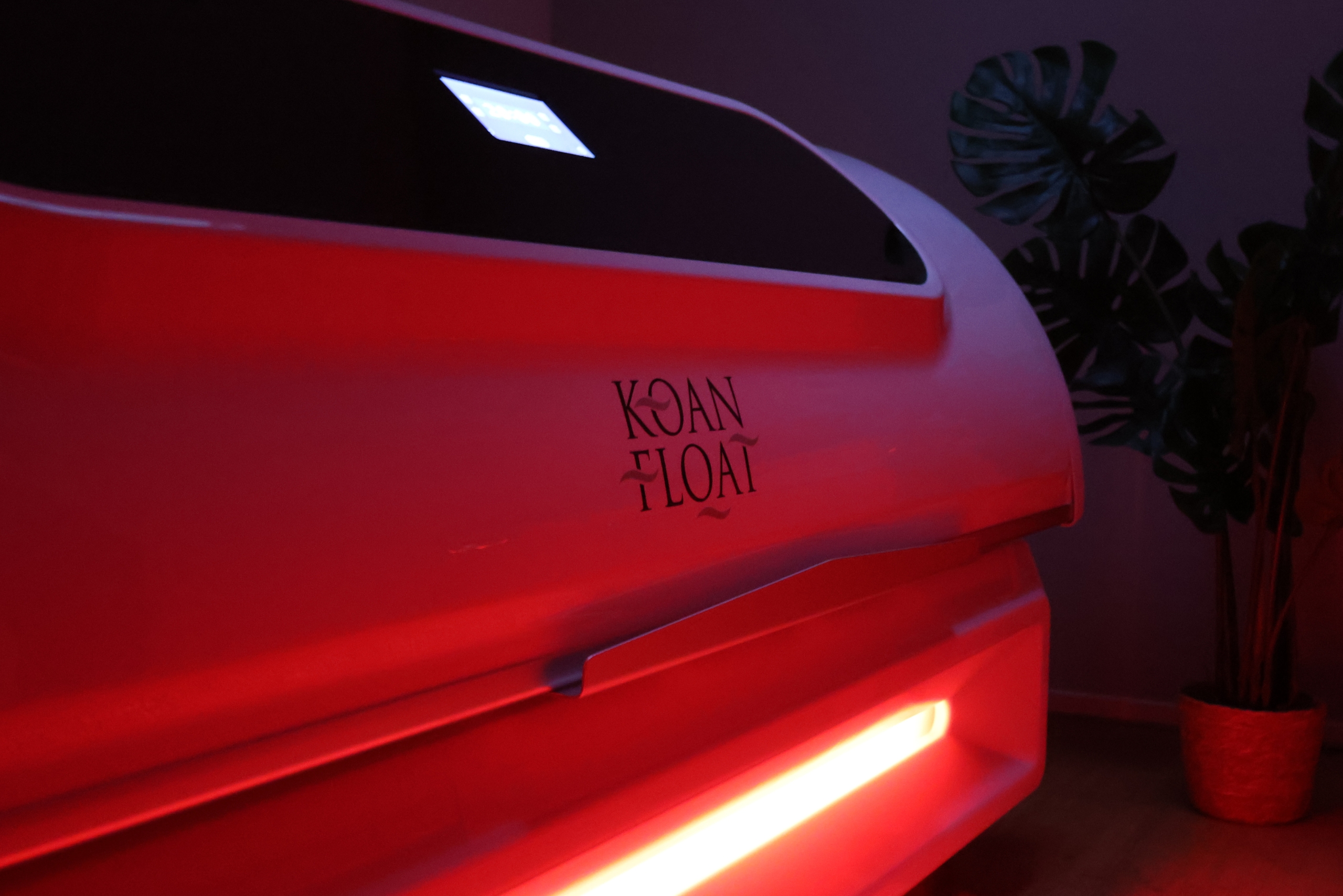 Logo van Koan Float bij de red light therapy banken in de wellnessruimte